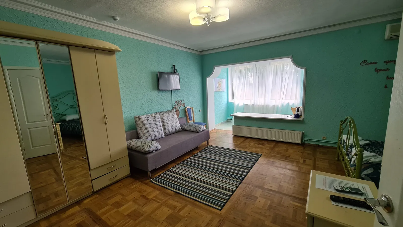 Номер с диваном, шкафом и телевизором