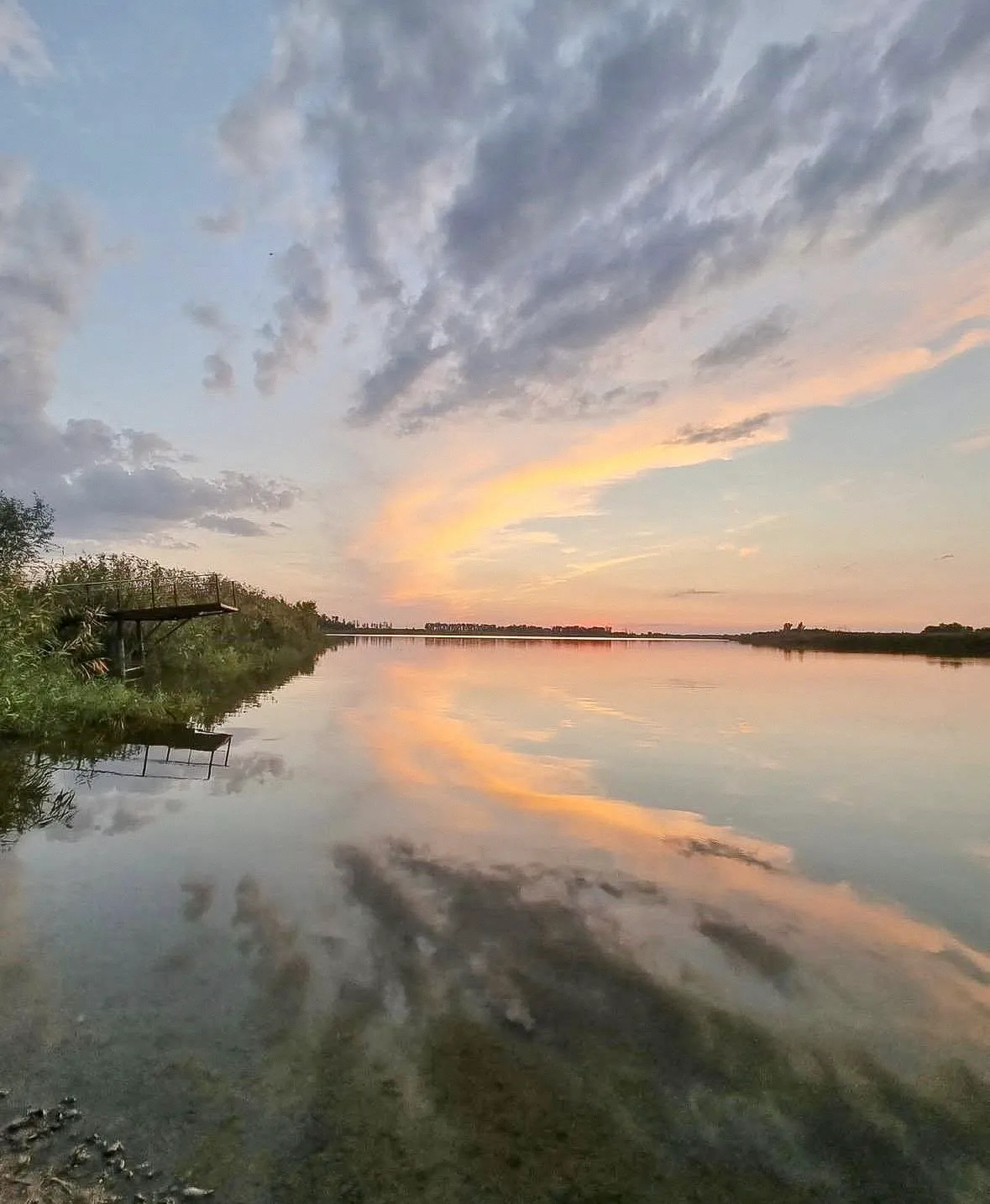 Водоём с отражением закатного неба
